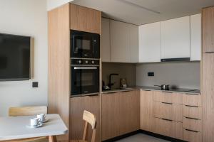 a kitchen with white cabinets and black appliances at Apartamentos Estival Park in La Pineda