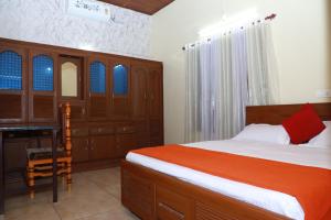 a bedroom with a bed and a desk in it at CITADEL HOLIDAY HOME in Vythiri