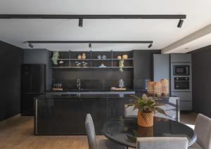 a dining room with a glass table and a kitchen at Ancorar Hospedagens in João Pessoa