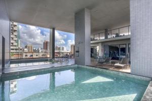 a swimming pool in a building with a view of the city at Ancorar Hospedagens in João Pessoa