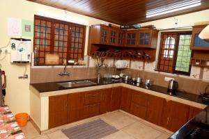 a kitchen with wooden cabinets and a sink at CITADEL HOLIDAY HOME in Vythiri