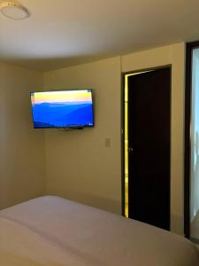 a bedroom with a bed and a flat screen tv on the wall at Monte Bravo Lodge in Yopal +6 photos