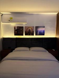 a bedroom with a bed with three pictures on the wall at Monte Bravo Lodge in Yopal