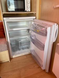 a small refrigerator with its door open in a kitchen at Vickys Walls Bungalow in Pataias