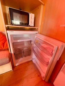 a refrigerator with its door open with a microwave at Vickys Walls Bungalow in Pataias +14 photos