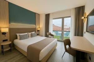 a hotel room with a bed and a balcony at Occidental Faro in Faro +50 photos