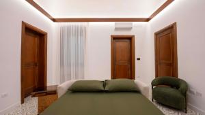 a bedroom with a green bed and a green chair at The Suite - Trani centro in Trani