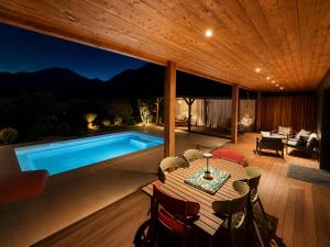 a patio with a table and a swimming pool at Villas Vallée d'ASCO in Moltifao
