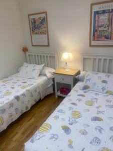 a bedroom with two beds and a table with a lamp at Apartamento Casalarreina in Casalarreina