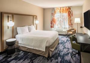 a hotel room with a large bed and a television at Fairfield By Marriott Middletown Monroe in Middletown