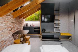 a kitchen with black cabinets and a brick wall at Apartamenty Wieliczka in Wieliczka