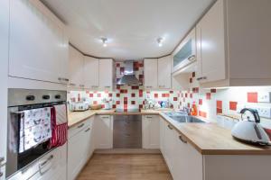een keuken met witte kasten en een wastafel bij Apartment Jamaica Street 7 in Edinburgh