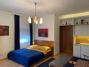 a bedroom with a blue bed in a room at Villa Gabriela Boutique Pension in Pörtschach in Pörtschach am Wörthersee