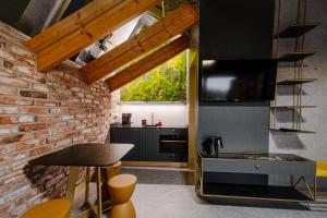 a kitchen with black cabinets and a brick wall at Apartamenty Wieliczka in Wieliczka +19 photos