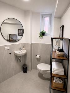 a bathroom with a sink and a toilet and a mirror at Boutique Hotel Celler Altstadt - 24h Check-in in Celle