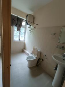 a bathroom with a toilet and a sink at CLOUDS Hotel and restaurant in Gangtok