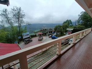 a balcony with a view of a town with cars at CLOUDS Hotel and restaurant in Gangtok
