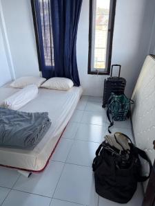 a room with a bed and a backpack on the floor at Rusde's Komodo Homestay in Pulau Komodo