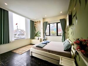 a bedroom with a bed and a large window at The Little Leaf Hostel - Restaurant & Rooftop Bar CatBa in Cat Ba +90 photos