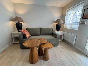 a living room with a couch and two tables at Charmante Maison avec Jardin Privé - PACY SUR EURE in Pacy-sur-Eure