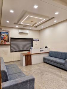 a waiting room with couches in front of a screen at Hotel Keshar Palace Shani Shingnapur in Sonai