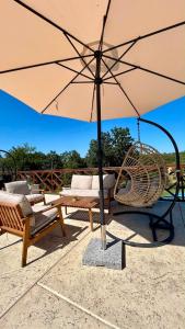 a patio with an umbrella and chairs and a swing at SoL Zlatni koreni in Palanka
