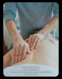 a woman is placing her hands on the back of a patient at VILLA ARTEMIA - chambre d hôtes labellisée massages-piscine-climatisation in Sigean