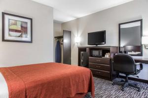 a hotel room with a bed and a flat screen tv at Danbury Inn & Suites in Danbury