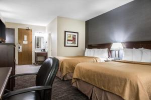 a hotel room with two beds and a chair at Danbury Inn & Suites in Danbury