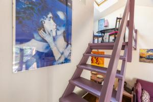 a purple staircase in a room with a painting at Hostdomus - Purple Apartment in Cesana Torinese