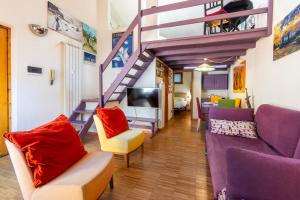 a living room with purple furniture and a staircase at Hostdomus - Purple Apartment in Cesana Torinese +8 photos