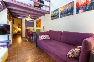 a living room with a purple couch and a table at Hostdomus - Purple Apartment in Cesana Torinese