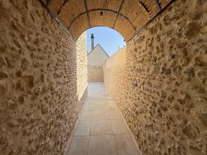 an alley in a building with a brick wall at Charmante Maison avec Jardin Privé - PACY SUR EURE in Pacy-sur-Eure +5 photos