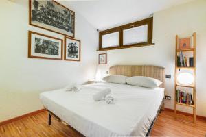 a bedroom with a large white bed in a room at Hostdomus - Purple Apartment in Cesana Torinese