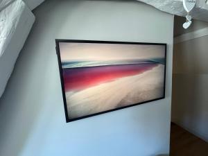 a flat screen tv hanging on a wall at Charmante Maison avec Jardin Privé - PACY SUR EURE in Pacy-sur-Eure