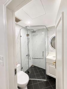 a bathroom with a shower and a toilet and a sink at Sora Westlake - Modern Apartment with Balcony in Hanoi +63 photos