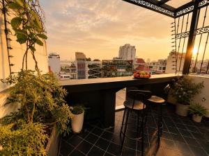 a balcony with a table and stools on a building at Sora Westlake - Modern Apartment with Balcony in Hanoi
