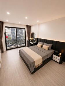 a bedroom with a large bed and a large window at Sora Westlake - Modern Apartment with Balcony in Hanoi