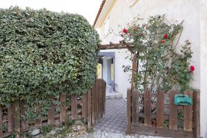 an entrance to a house with a wooden gate with roses at Appartement Aléria avec jardin in Aléria
