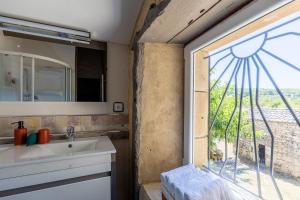 a bathroom with a sink and a window at Maison de Charme en Pleine Nature in Bournazel