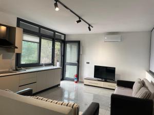 a living room with a couch and a flat screen tv at Oksijen in Urla