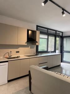 a kitchen with white cabinets and a couch in it at Oksijen in Urla