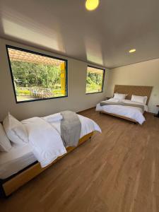 zwei Betten in einem Zimmer mit zwei Fenstern in der Unterkunft Salento River Hotel in Salento + 27 Fotos