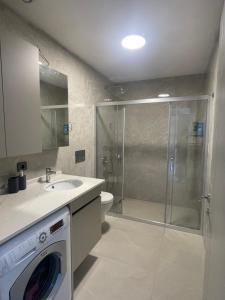a bathroom with a shower and a washing machine at Oksijen in Urla +9 photos