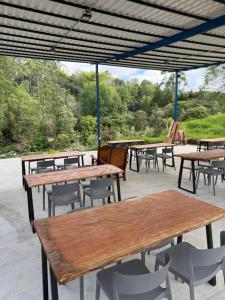 eine Gruppe von Tischen und Stühlen unter einem Dach in der Unterkunft Salento River Hotel in Salento