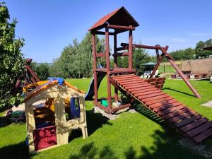 a playground with a wooden slide and a play structure at Noclegi Na Wzgórzu in Krajno Pierwsze