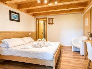 a bedroom with a bed in a room with wooden ceilings at Chalet - Margherita in Sappada