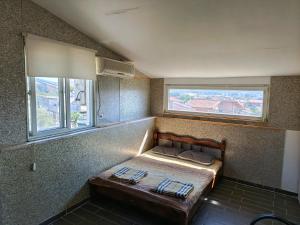a small bed in a room with two windows at Solara in Bar