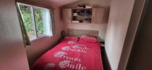 a small bedroom with a red bed in a room at Heatherview Willerby in Bishop Auckland
