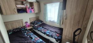a small room with two beds and a window at Heatherview Willerby in Bishop Auckland